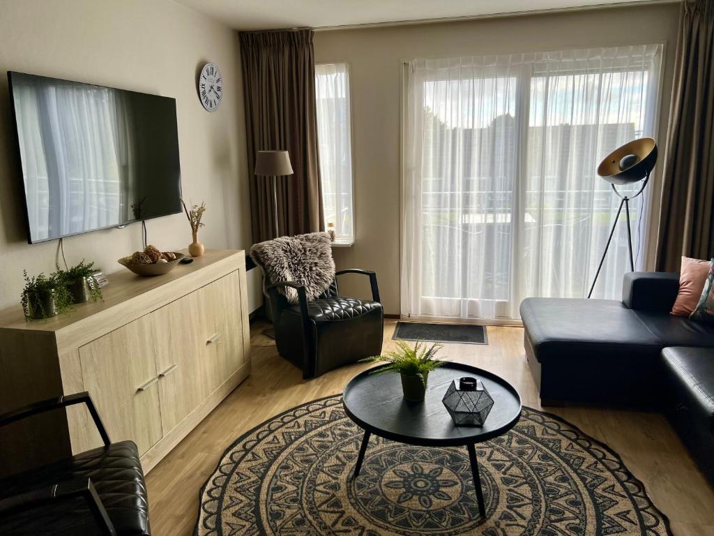una sala de estar con un sofá y una mesa en Appartement Ut & Thus, Resort Amelander Kaap, en Hollum