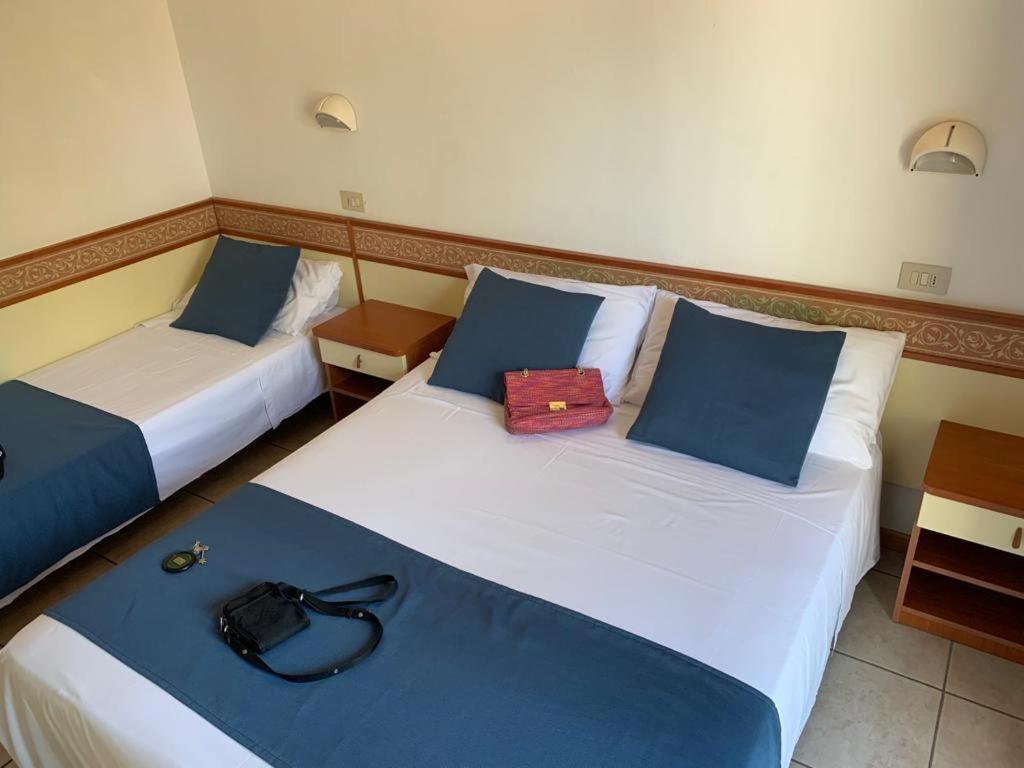 2 Betten in einem Hotelzimmer mit Handtasche drauf in der Unterkunft Des Bains 138 B&B in Milano Marittima