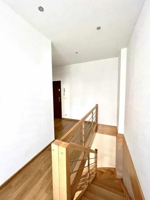 a staircase in a room with white walls and wooden floors at Mieszkanie Kolejarz in Gdańsk