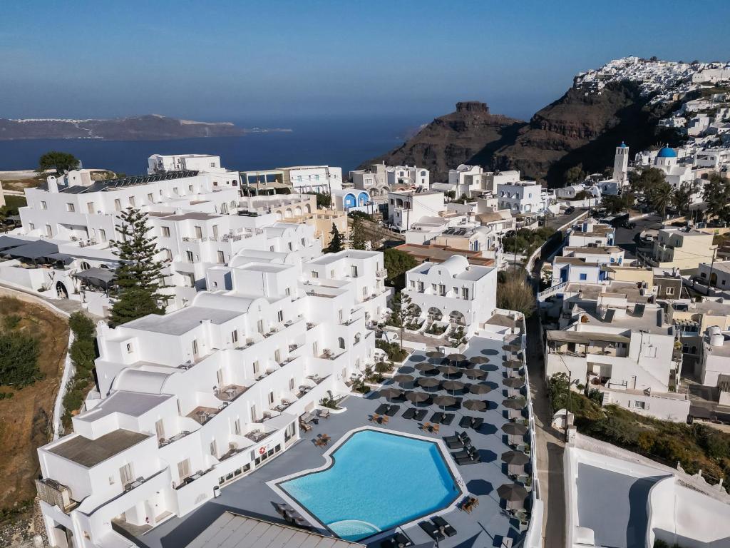 une vue aérienne sur une ville avec des bâtiments blancs dans l'établissement Santorini Palace, à Fira