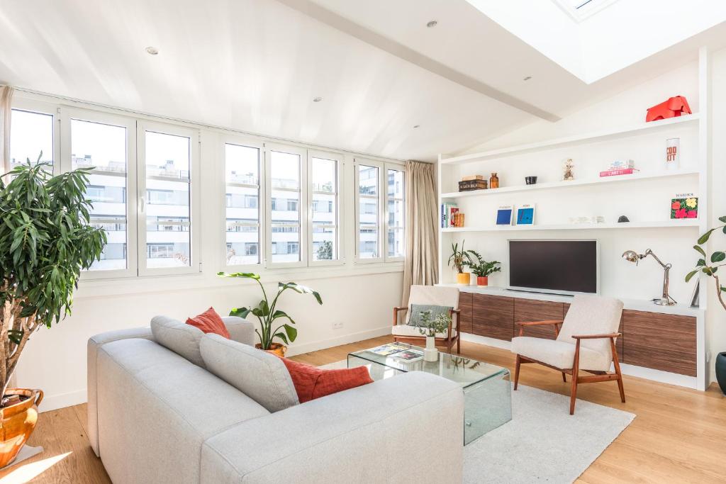 un salon avec un canapé et une télévision dans l'établissement Penthouse Loft - 4 guests - in heart of Paris, à Paris