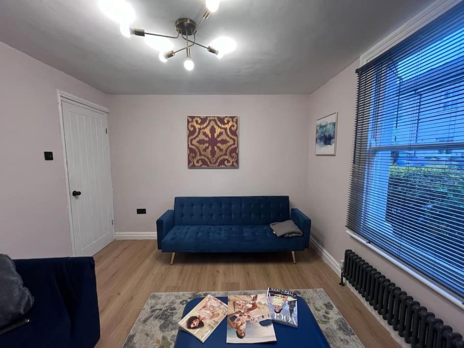 een woonkamer met een blauwe bank en een tafel bij Stunning 3 bedroom house sleeps up to 6 in Norwood