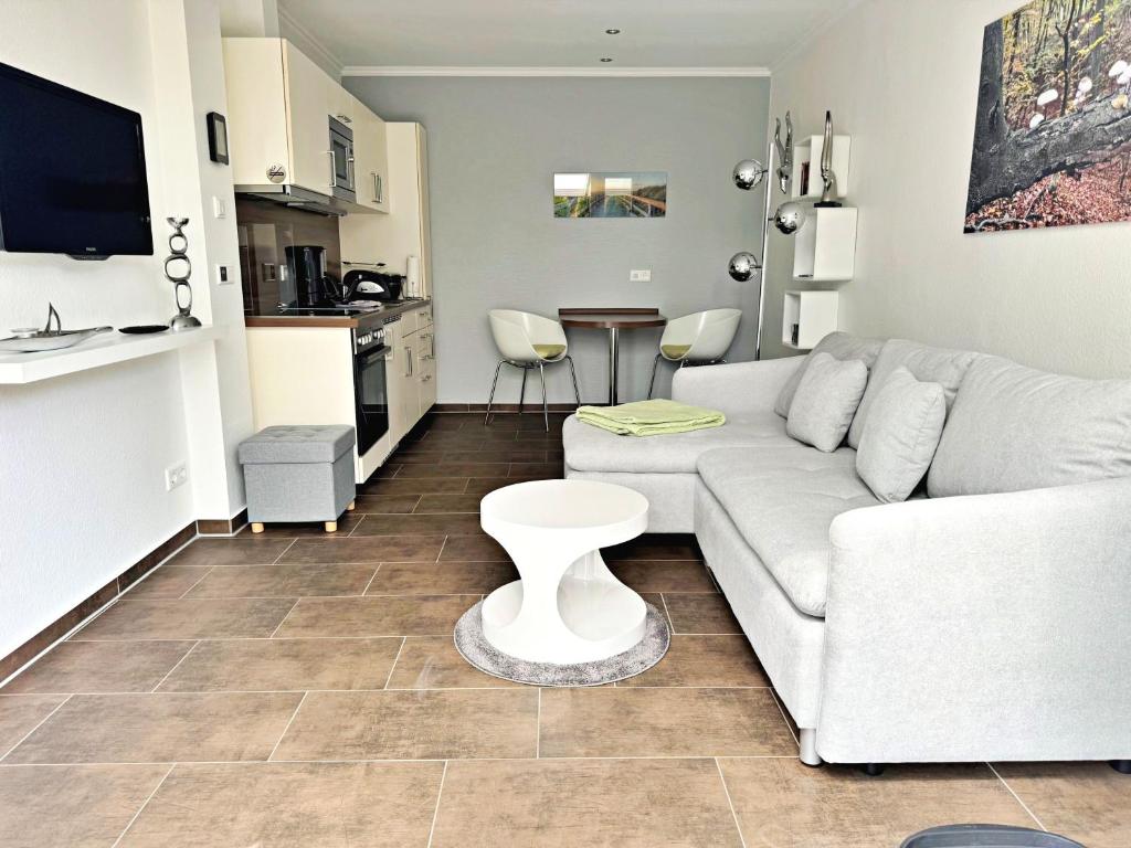 a living room with a white couch and a table at Ferienwohnung Altenberg 02 in Ahlbeck