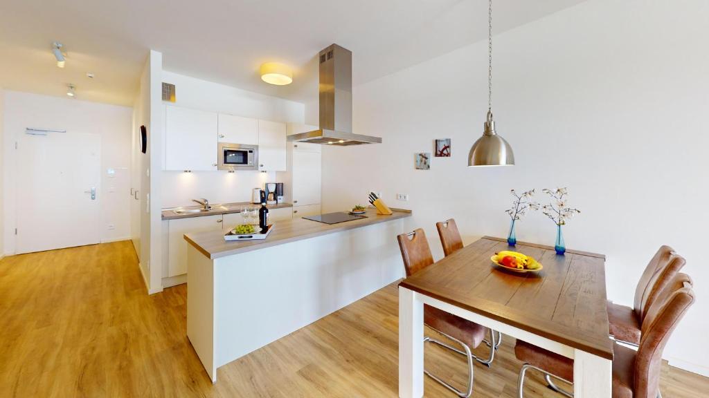 a kitchen and dining room with a wooden table at Südkap G-06 in Pelzerhaken