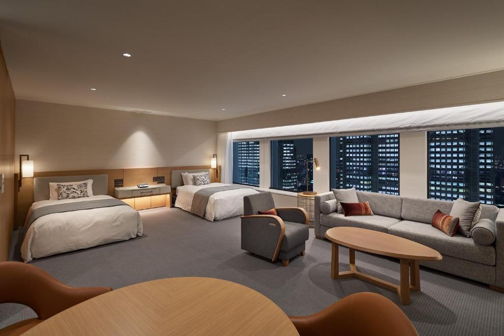 a hotel room with two beds and a couch at Keio Plaza Hotel Tokyo in Tokyo