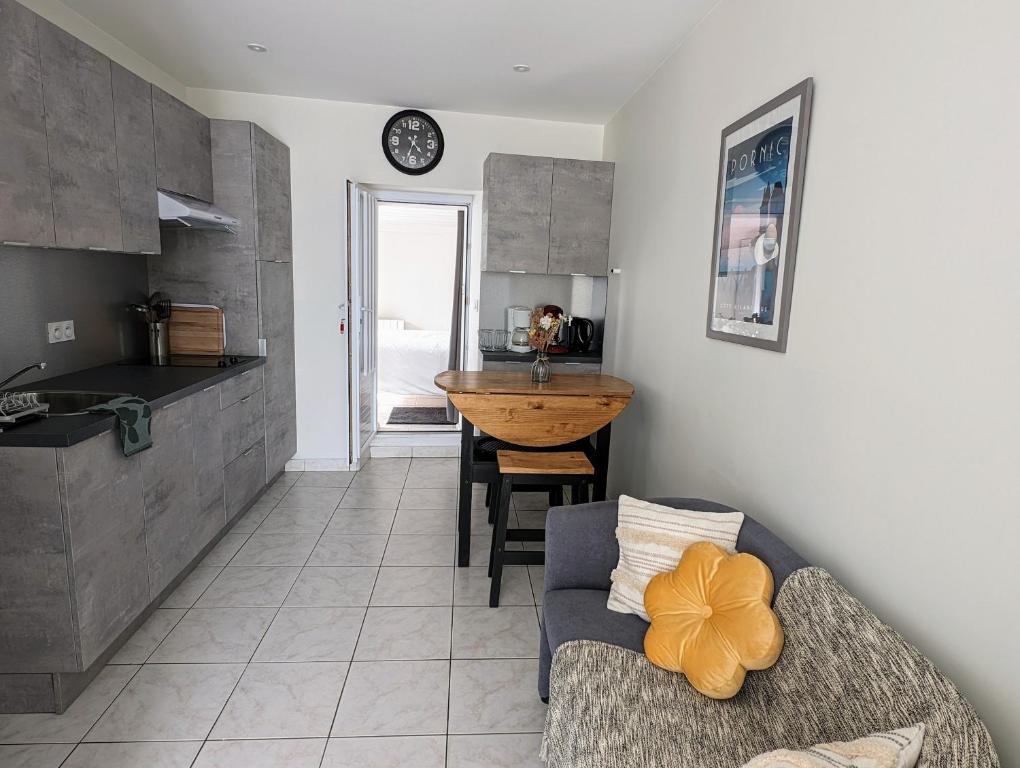 une cuisine et un salon avec un canapé et une table dans l'établissement Pied-à-terre proche du centre et commodités, à Pornic