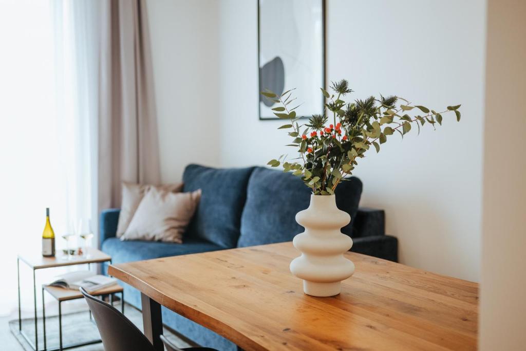 a vase with flowers on a table in a living room at Apartmány Dog in Dock in Veselí nad Moravou