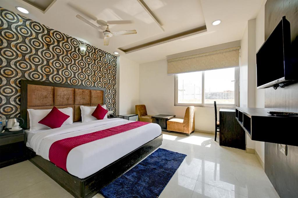 Dormitorio con cama, escritorio y TV en Hotel Seven Inns Qubic Near Delhi Airport, en Nueva Delhi