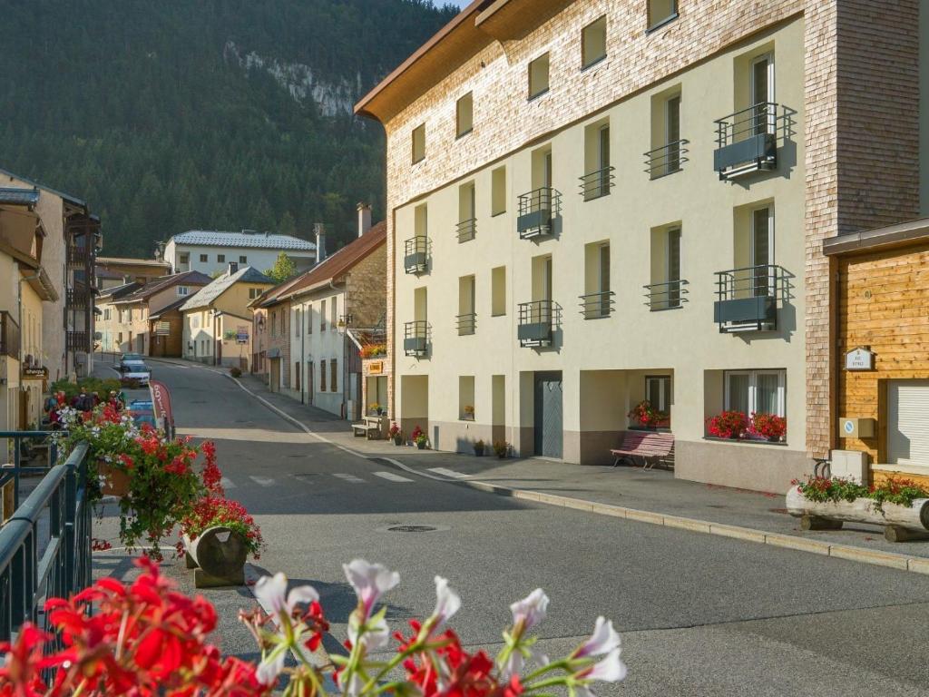 eine leere Straße in einer Stadt mit Gebäuden und Blumen in der Unterkunft Dvacances Résidence les tavaillons in Mijoux