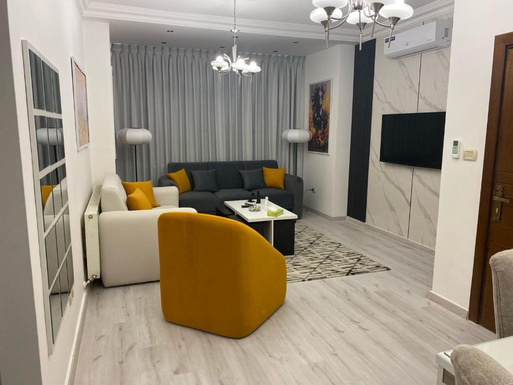 ein Wohnzimmer mit einem Sofa und einem gelben Stuhl in der Unterkunft Kinzo1 in Amman
