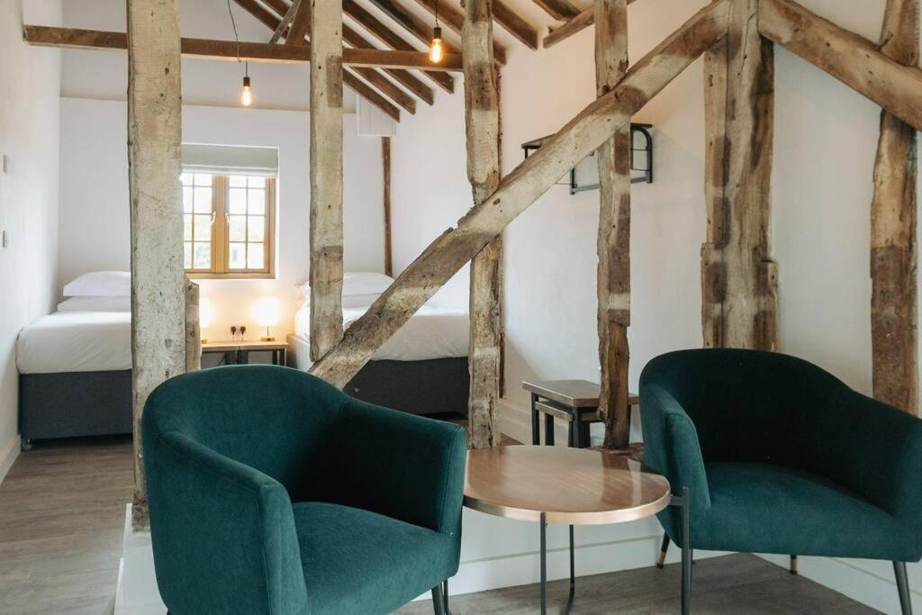 two chairs and a table in a room with a bed at 5 Henham Barns in Beccles