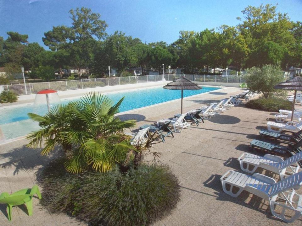 a pool with a bunch of chairs and umbrellas at mobilhome 6/8 personnes in La Tremblade