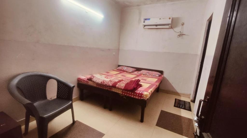 新德里的住宿－BANSAL INN Near Aiims Hospital，小房间设有一张小床和一把椅子