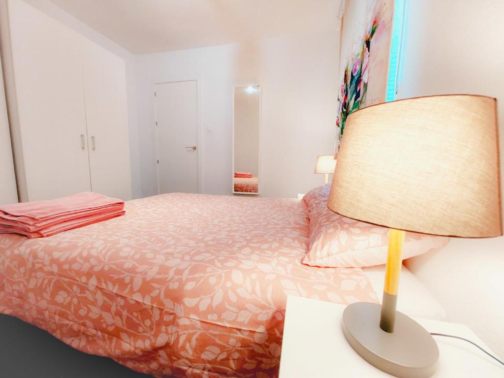Un dormitorio con una cama y una lámpara en un escritorio. en Alojamiento Amelie con WiFi gratis, en Murcia