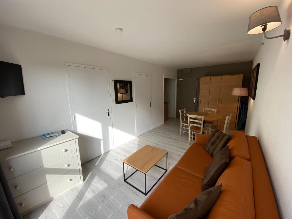 - un salon avec un canapé orange et une table dans l'établissement Joli T2 Résidence du Golf avec terrasse, à Bénodet