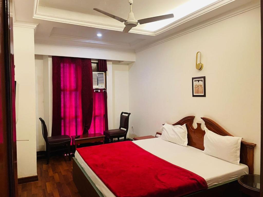 a bedroom with a large bed with a red blanket at HOTEL PLAZA GRAND in Jalandhar