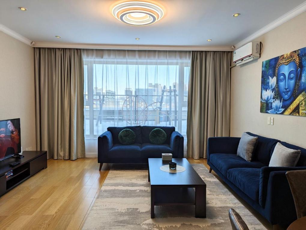 a living room with a blue couch and a table at Buddha Vista Luxury apartment in Ulaanbaatar