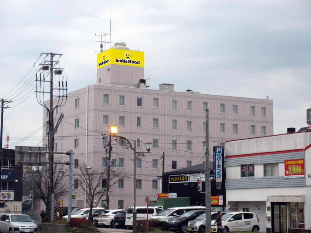 a building with a yellow sign on the top of it at Smile Hotel Kushiro in Kushiro