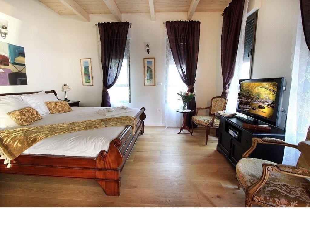 a bedroom with a bed and a flat screen tv at Oak Shade in Bet Leẖem HaGelilit