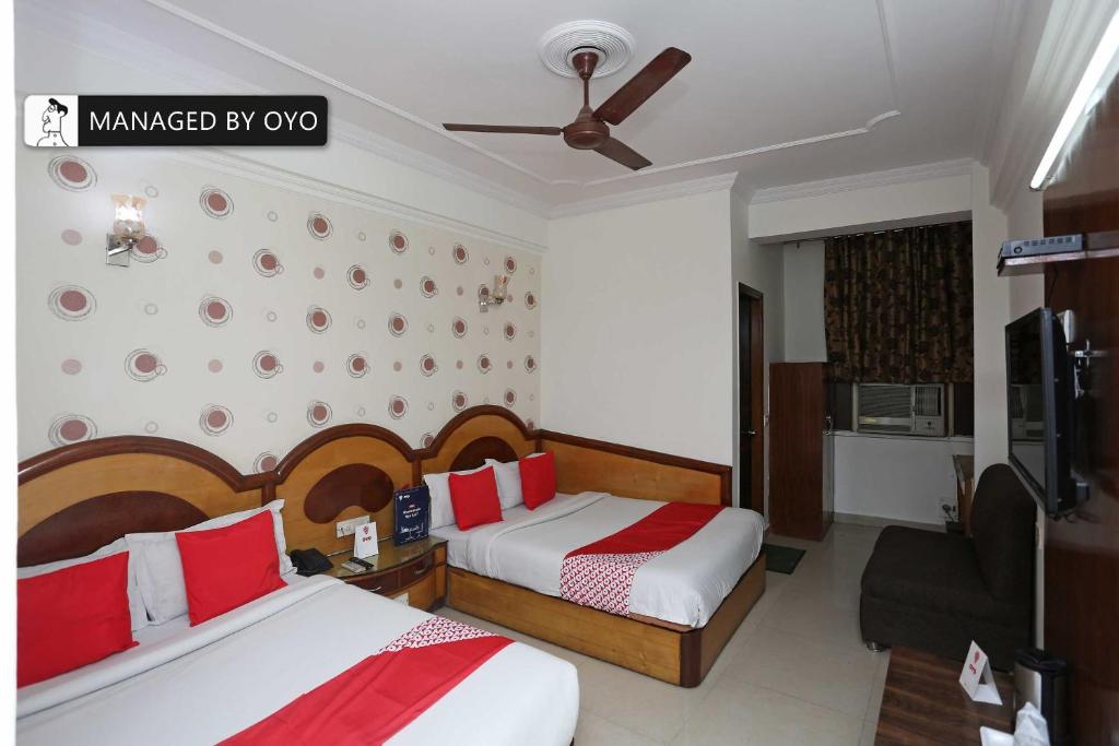 Habitación de hotel con 2 camas y TV en OYO Pallvi Palace Paharganj Near New Delhi Railway Station, en Nueva Delhi