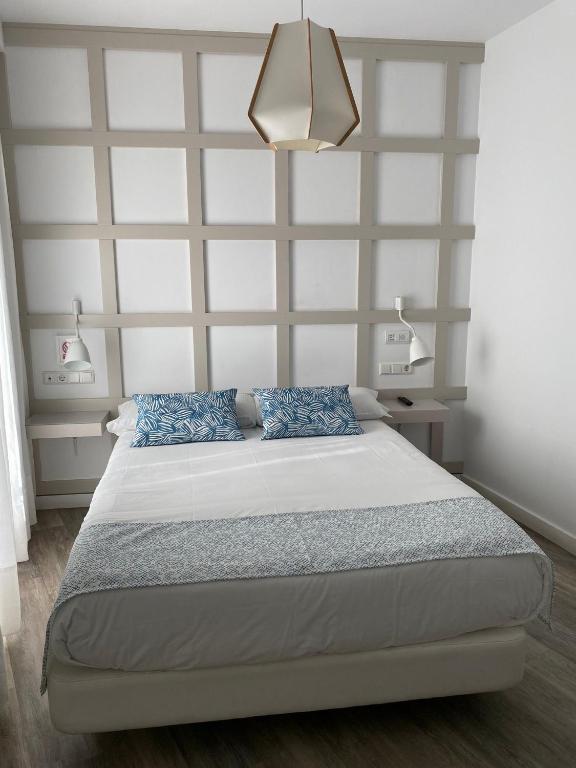 sypialnia z dużym łóżkiem z niebieskimi poduszkami w obiekcie Hotel Boutique Teatro Romano w Maladze