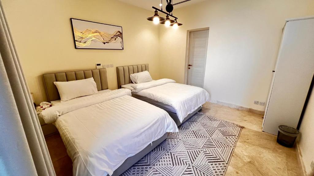 1 dormitorio con 2 camas y alfombra en شقة غرفتين وصاله مطله على البحر برج ابحر ريزيدنس 1 en Obhor