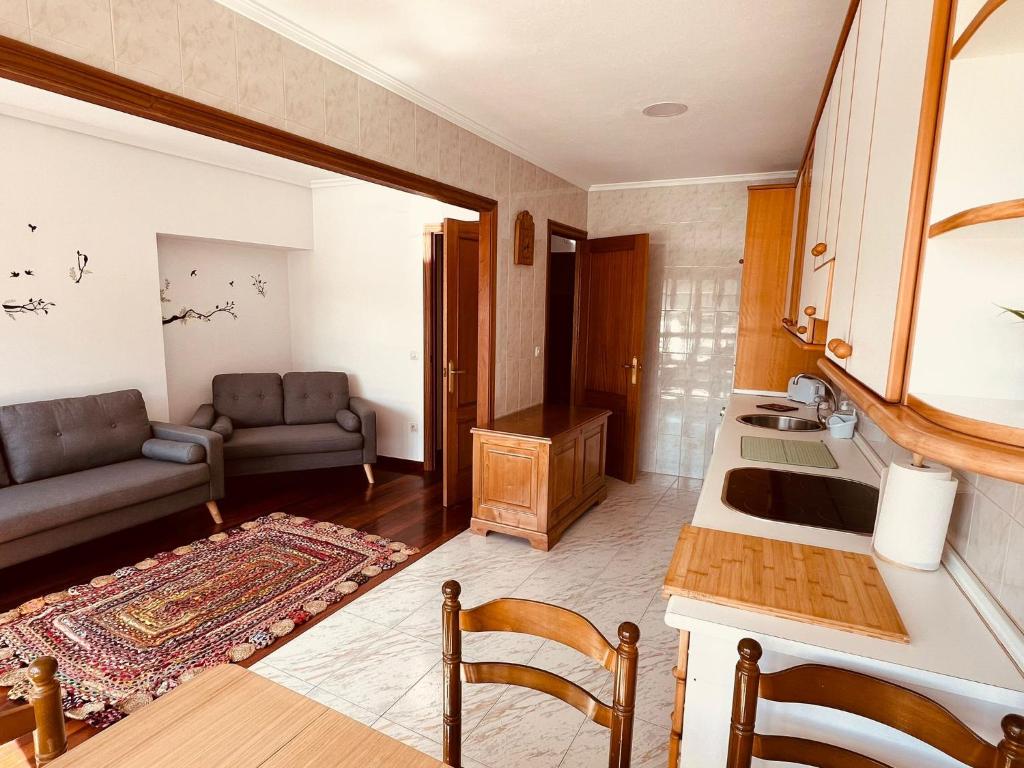 eine Küche und ein Wohnzimmer mit einem Sofa und einem Tisch in der Unterkunft MartinVidal 2 in Luarca