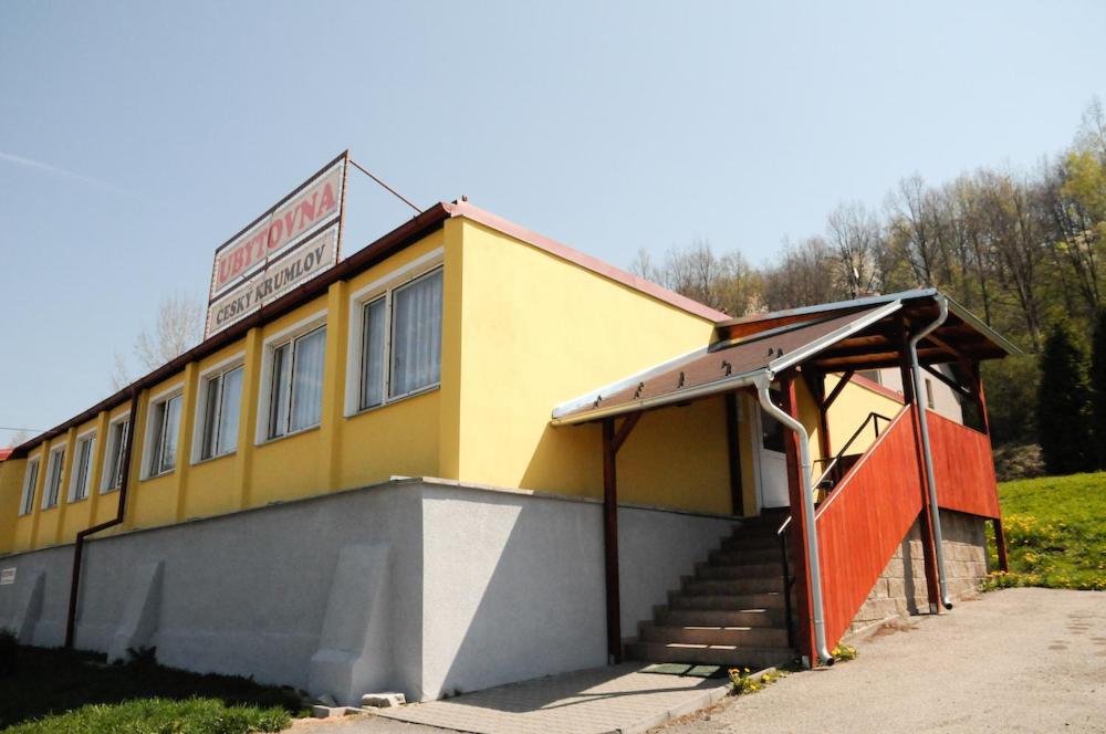 un edificio amarillo con escaleras y un cartel en él en Ubytovna Český Krumlov en Český Krumlov