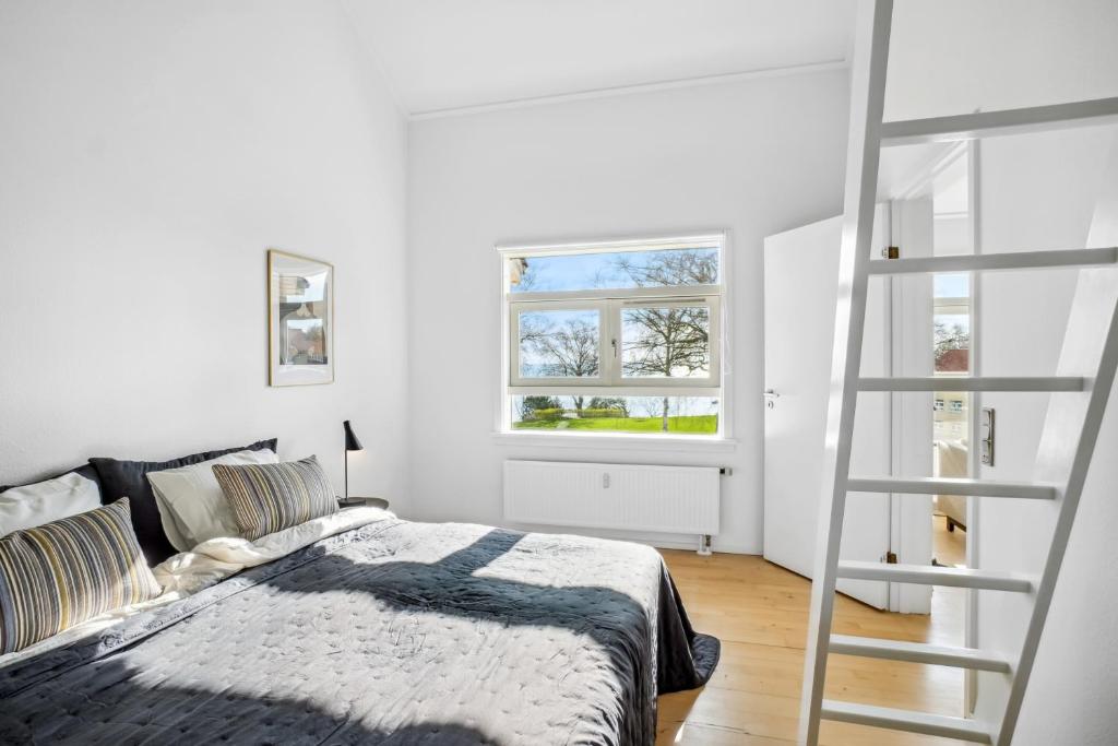 a bedroom with a bed and a ladder at Come Stay 3BR - Havudsigt m.plads til 5 personer in Hørsholm