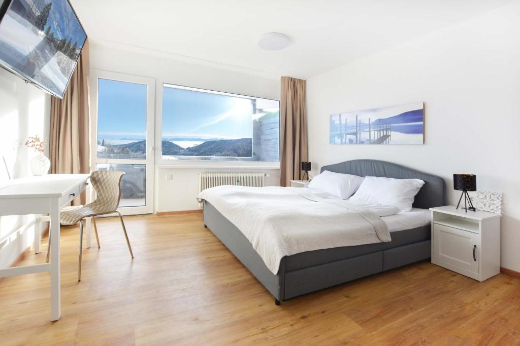 a bedroom with a bed and a desk and windows at Ferienwohnung Simonhöhe in Zirkitz