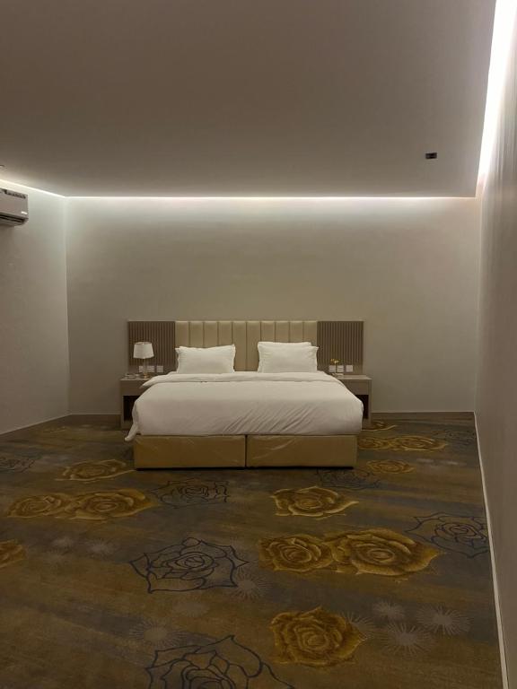 ein Schlafzimmer mit einem Bett und zwei Nachttischen und einem Bett sidx sidx sidx in der Unterkunft Golden Sword in Mogayra