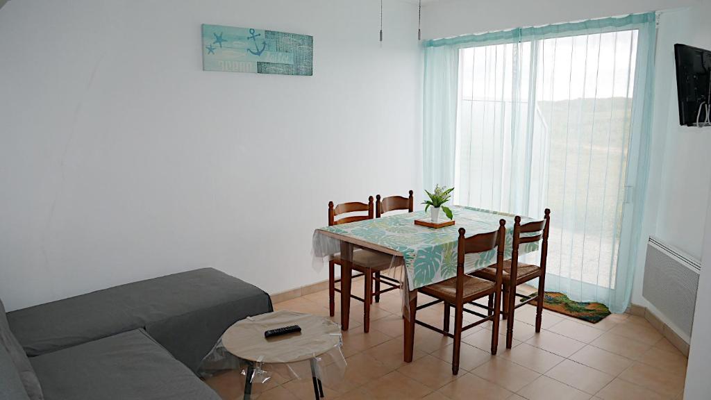 sala de estar con mesa, sillas y sofá en Appartement à 50 mètres de la plage, en Saint-Jean-de-Monts