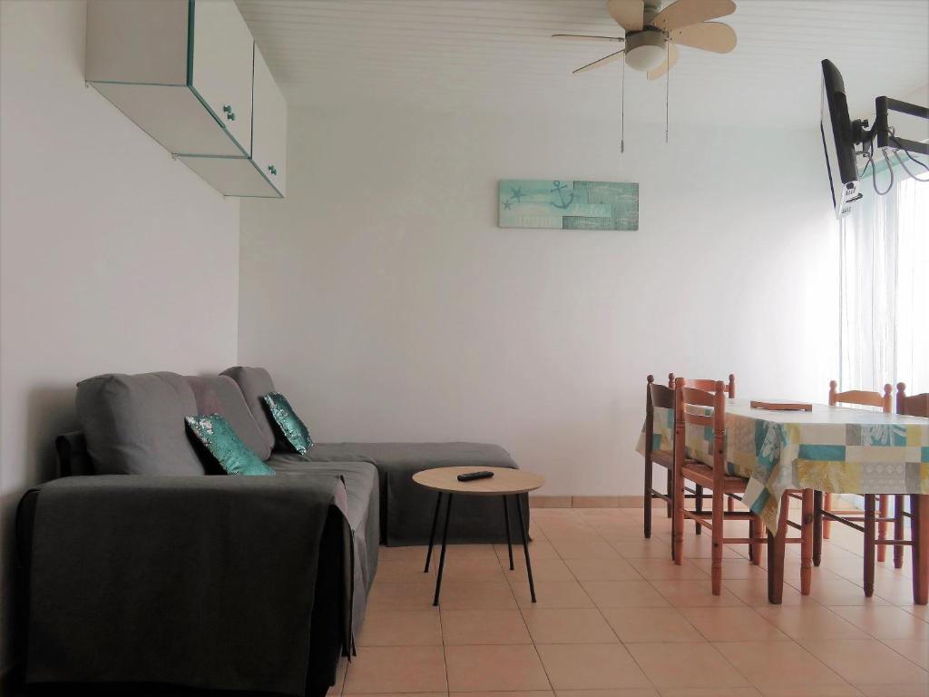 un salon avec un canapé et une table dans l'établissement Appartement à 50 mètres de la plage, à Saint-Jean-de-Monts