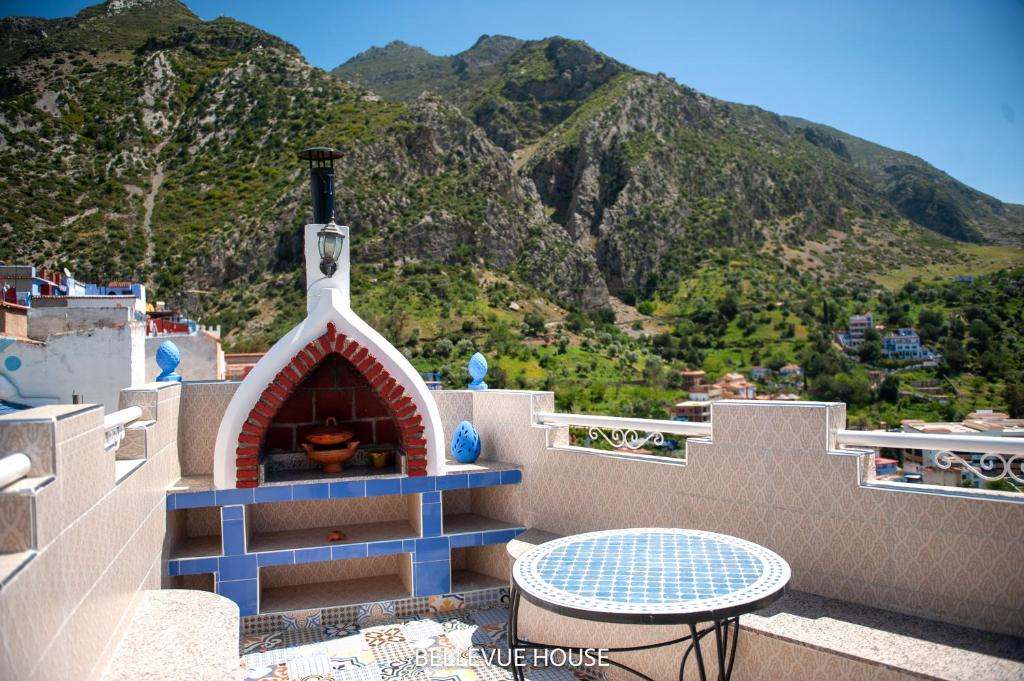 a balcony with a table and a pizza oven at BELLEVUE HOUSE - with terrace in the heart of medina in Chefchaouene