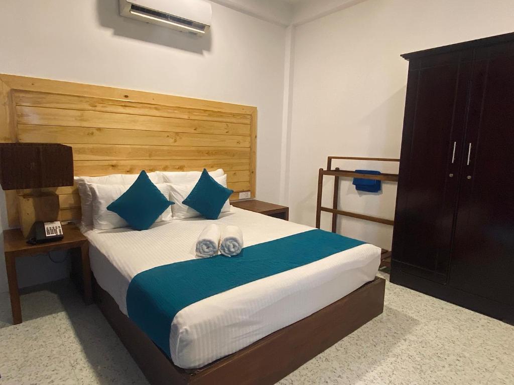 um quarto com uma cama com almofadas azuis e brancas em Trinco Beach Resort em Trincomalee