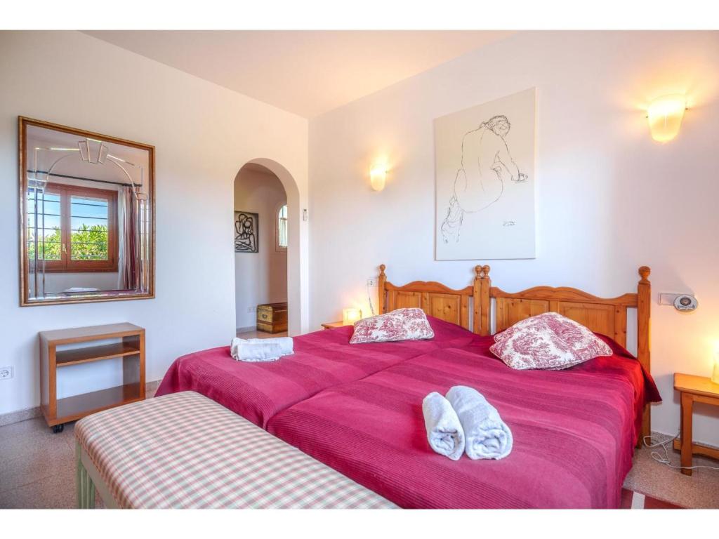 sypialnia z 2 łóżkami z różową pościelą i lustrem w obiekcie Holiday Home Sa Caseta by Interhome w mieście Muro
