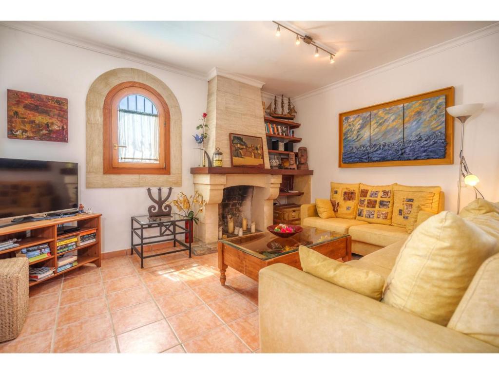 salon z kanapą i kominkiem w obiekcie Holiday Home Sa Caseta by Interhome w mieście Muro