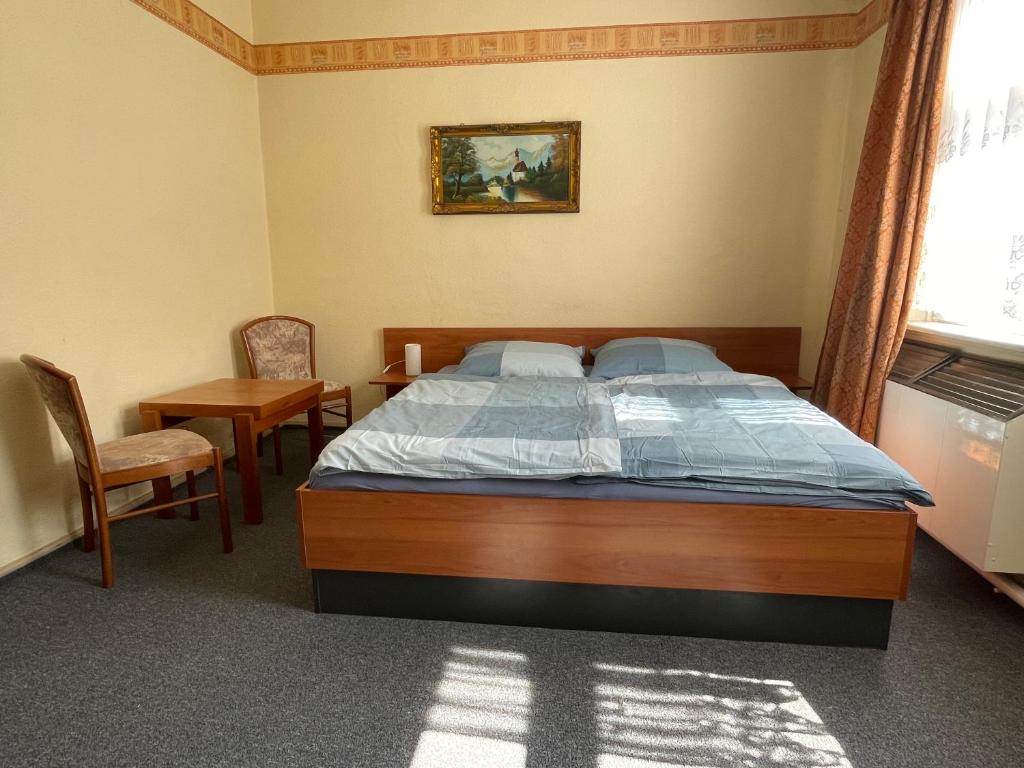 1 dormitorio con 1 cama, mesa y sillas en Kimbab Restaurant und Pension, en Ruhla