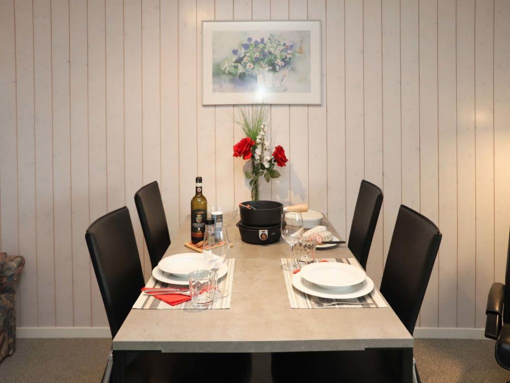 un tavolo da pranzo con sedie e un tavolo con bicchieri da vino di Apartment Arlette Nr- 34 by Interhome a Gstaad