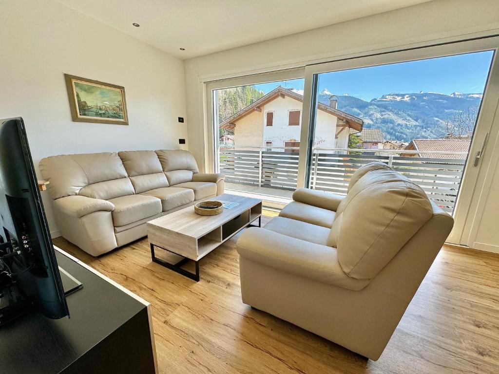 a living room with two couches and a large window at Villa Dada in Predazzo