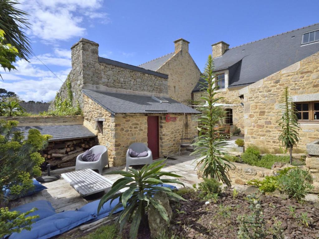 une maison en pierre avec deux chaises et une porte rouge dans l'établissement Holiday Home La Demeure de Tumiac by Interhome, à Arzon