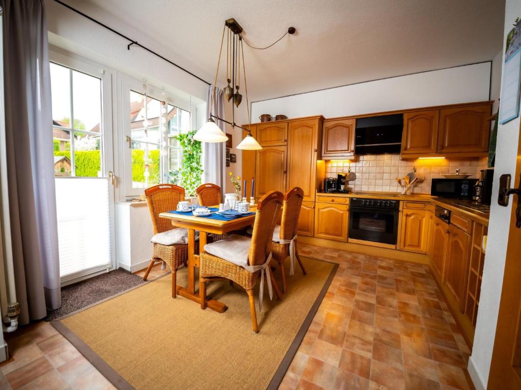 eine Küche mit einem Tisch und Stühlen sowie eine Küche mit einem Fenster in der Unterkunft Holiday Home Haus am Berg der Osterräder by Interhome in Lügde