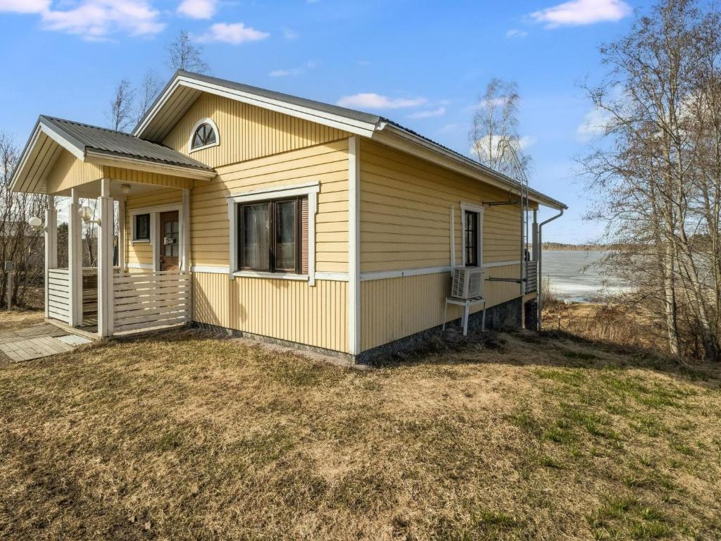 uma pequena casa amarela em cima de um quintal em Holiday Home Pikku-puntila by Interhome em Niemikylät