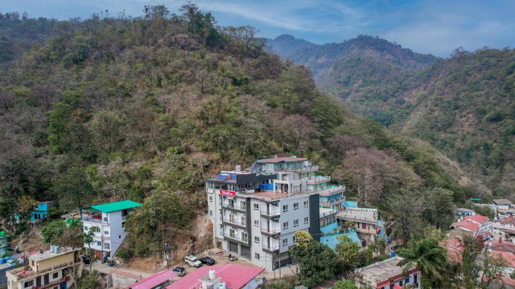 un edificio al lado de una montaña en Levelup Plus Pinaaki Inn, en Rishīkesh