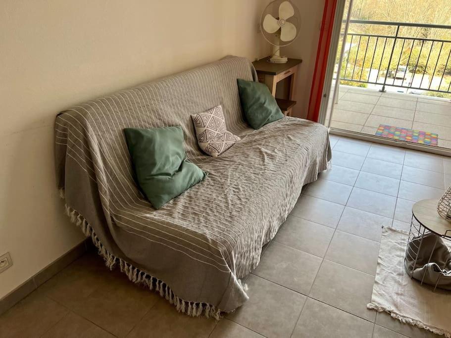 a couch with pillows on it in a room at San José in Juvignac