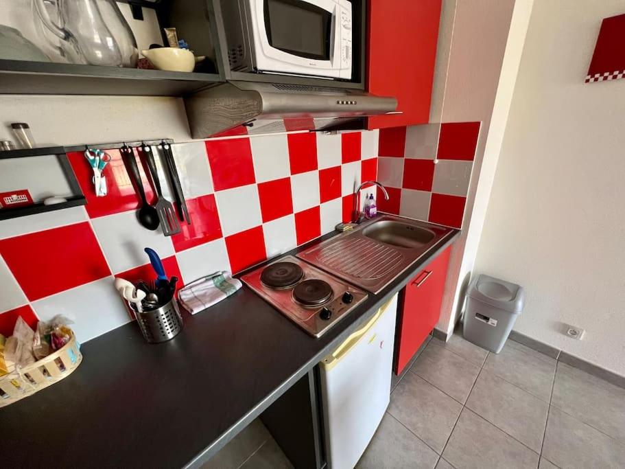 a small kitchen with a stove and a microwave at San José in Juvignac