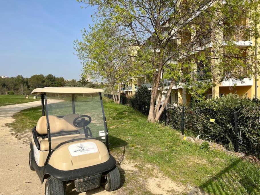 a golf cart parked in the grass next to a house at San José in Juvignac