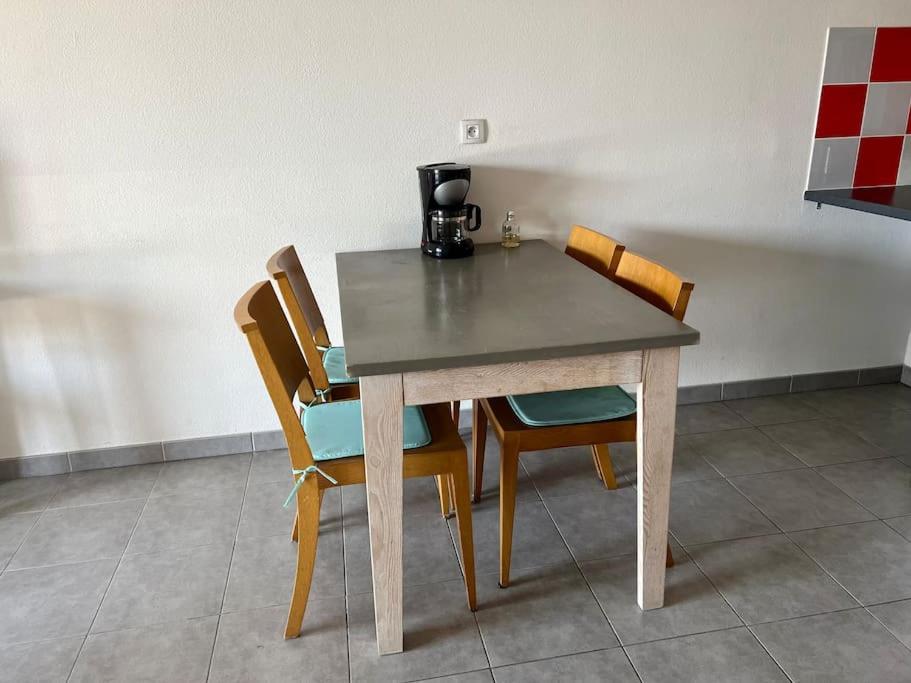 a table with chairs and a coffee maker on it at San José in Juvignac