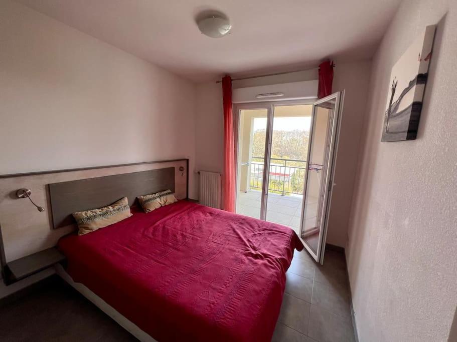 a bedroom with a red bed and a window at San José in Juvignac