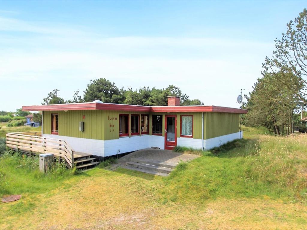 een klein groen huis in een veld bij Holiday Home Sweni - 800m from the sea in Western Jutland by Interhome in Fanø